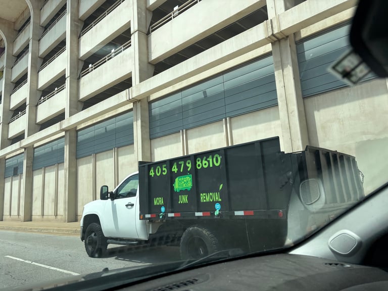 White junk removal truck with digital display showing phone number 405-479-8610